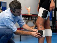 Dr. Scott Landry, Associate Professor and Director of the John MacIntyre mLAB (motion Laboratory of Applied Biomechanics) applies electrodes to a student’s leg.
